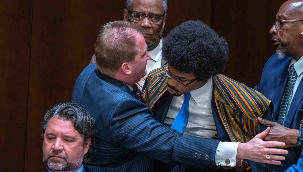 Tennessee Rep. Justin J. Pearson (right) is restrained as he confronts Rep. Andrew Farmer (left) during a heated House subcommittee hearing on gun laws