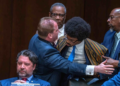 Tennessee Rep. Justin J. Pearson (right) is restrained as he confronts Rep. Andrew Farmer (left) during a heated House subcommittee hearing on gun laws
